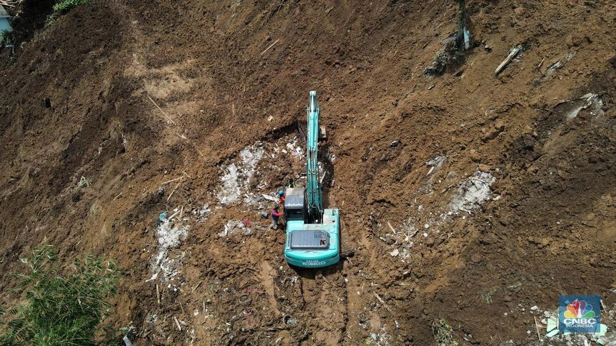 Alat berat mencari korban jiwa yang rumahnya rata dengan timbunan longsor di kawasan Cugenang, Kabupaten Cianjur, Selasa (22/11/2022). Perkampungan tersebut tertimbun material tebing yang longsor akibat guncangan gempa berkekuatan 5,6 magnitudo (M). (CNBC Indonesia/Andrean Kristianto)