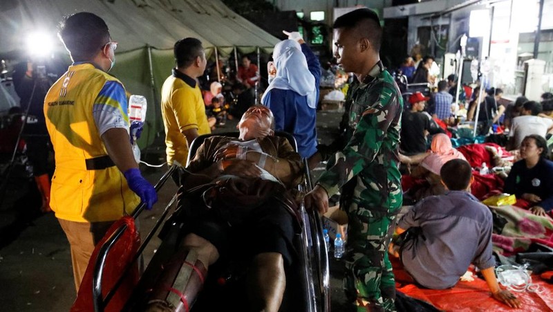 Korban selamat dirawat di luar rumah sakit kabupaten setelah gempa bumi melanda Cianjur, Provinsi Jawa Barat, Indonesia, 21 November 2022. (Anadolu Agency via Getty Images)