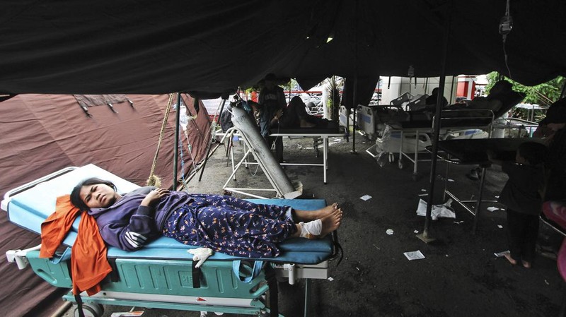 Korban selamat dirawat di luar rumah sakit kabupaten setelah gempa bumi melanda Cianjur, Provinsi Jawa Barat, Indonesia, 21 November 2022. (Anadolu Agency via Getty Images)