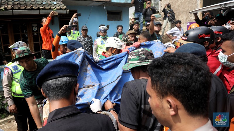 Petugas gabungan mengangkat jenazah korban tertimbun longsor akibat guncangan gempa berkekuatan 5,6 magnitudo (M) yang terjadi kemarin di desa Cijedil, Kampung Cugenang, Kecamatan Cugenang, Cianjur, Jawa Barat, Selasa (22/11/2022). Sebanyak dua jenazah diangkat dari timbunan longsor sekirar pukul 13.10 wib. (CNBC Indonesia/Andrean Kristianto)