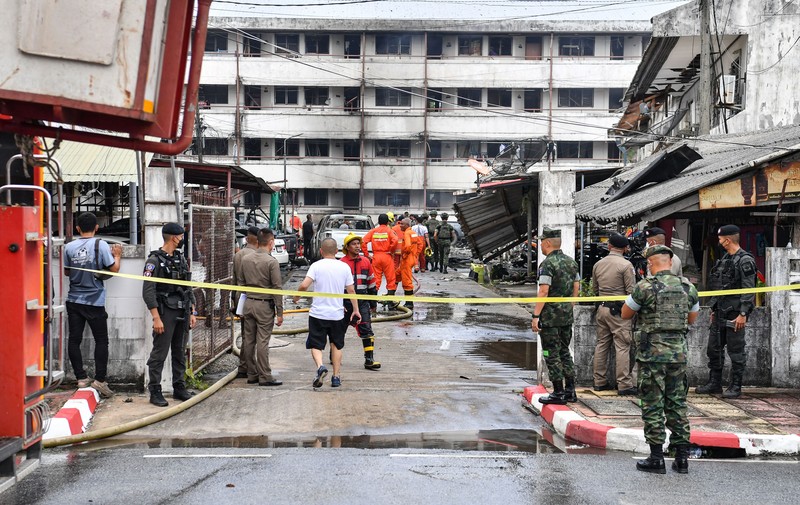 Sebuah bom mobil meledak di dalam kompleks kantor polisi di wilayah Thailand bagian selatan. Sedikitnya satu orang tewas dan puluhan orang lainnya mengalami luka-luka akibat ledakan ini. Police officials stand near a partly damaged car, after a car bomb exploded outside a police accommodation in Narathiwat town, southern Thailand, on November 22, 2022. - One person died and more than two dozen were injured in the attack, the provincial governor said. (Photo by MADAREE THOLALA / AFP) (Photo by MADAREE THOLALA/AFP via Getty Images)