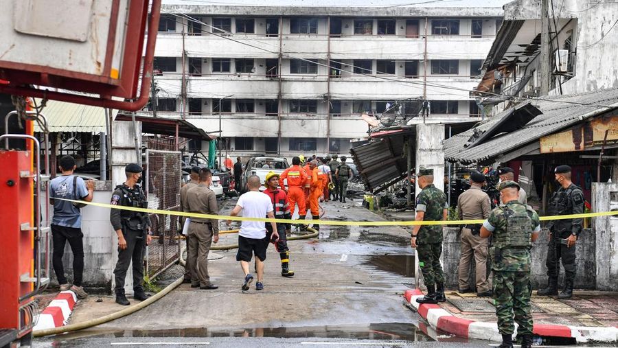 Police officials stand near a partly damaged car, after a car bomb exploded outside a police accommodation in Narathiwat town, southern Thailand, on November 22, 2022. - One person died and more than two dozen were injured in the attack, the provincial governor said. (Photo by MADAREE THOLALA / AFP) (Photo by MADAREE THOLALA/AFP via Getty Images)