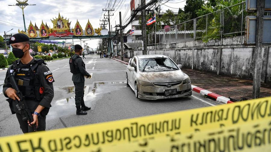 Police officials stand near a partly damaged car, after a car bomb exploded outside a police accommodation in Narathiwat town, southern Thailand, on November 22, 2022. - One person died and more than two dozen were injured in the attack, the provincial governor said. (Photo by MADAREE THOLALA / AFP) (Photo by MADAREE THOLALA/AFP via Getty Images)
