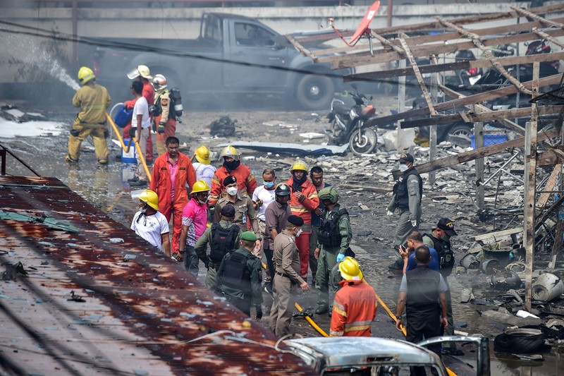 Sebuah bom mobil meledak di dalam kompleks kantor polisi di wilayah Thailand bagian selatan. Sedikitnya satu orang tewas dan puluhan orang lainnya mengalami luka-luka akibat ledakan ini. Police officials stand near a partly damaged car, after a car bomb exploded outside a police accommodation in Narathiwat town, southern Thailand, on November 22, 2022. - One person died and more than two dozen were injured in the attack, the provincial governor said. (Photo by MADAREE THOLALA / AFP) (Photo by MADAREE THOLALA/AFP via Getty Images)