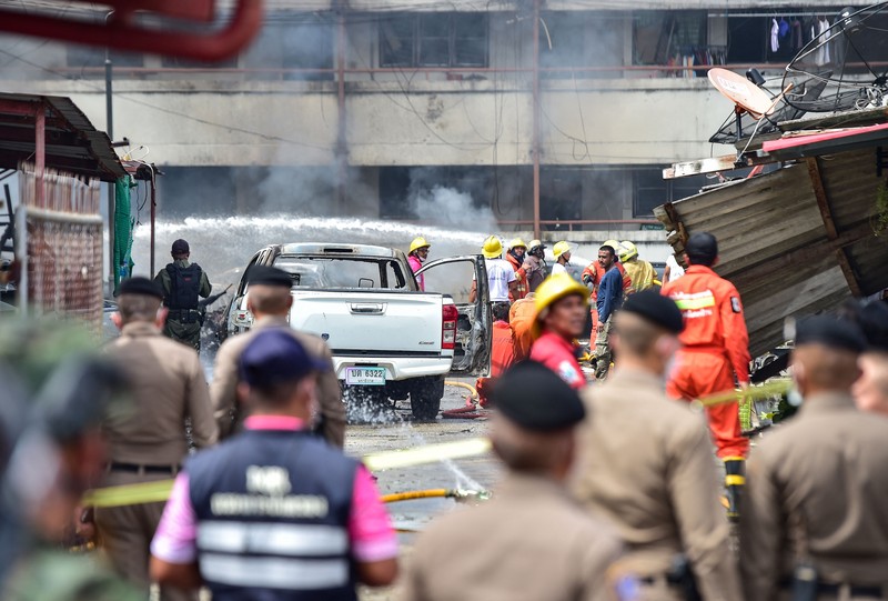 Sebuah bom mobil meledak di dalam kompleks kantor polisi di wilayah Thailand bagian selatan. Sedikitnya satu orang tewas dan puluhan orang lainnya mengalami luka-luka akibat ledakan ini. Police officials stand near a partly damaged car, after a car bomb exploded outside a police accommodation in Narathiwat town, southern Thailand, on November 22, 2022. - One person died and more than two dozen were injured in the attack, the provincial governor said. (Photo by MADAREE THOLALA / AFP) (Photo by MADAREE THOLALA/AFP via Getty Images)