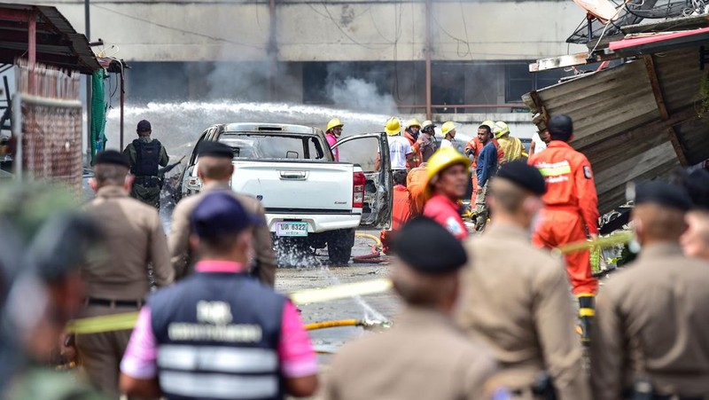 Police officials stand near a partly damaged car, after a car bomb exploded outside a police accommodation in Narathiwat town, southern Thailand, on November 22, 2022. - One person died and more than two dozen were injured in the attack, the provincial governor said. (Photo by MADAREE THOLALA / AFP) (Photo by MADAREE THOLALA/AFP via Getty Images)