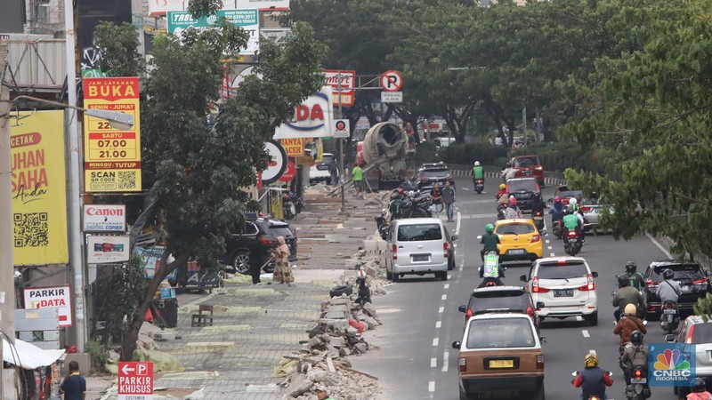 Proyek trotoar Jalan Margonda Raya baik yang ke arah Jakarta maupun sebaliknya. Secara garis besar kondisi trotoar sudah hampir tuntas tetapi lubang-lubang drainase tampak belum tertutup. (CNBC Indonesia/ Muhammad Sabki)