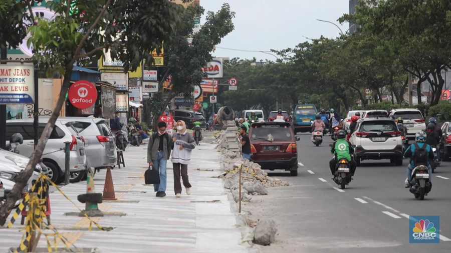 Proyek trotoar Jalan Margonda Raya baik yang ke arah Jakarta maupun sebaliknya. Secara garis besar kondisi trotoar sudah hampir tuntas tetapi lubang-lubang drainase tampak belum tertutup. (CNBC Indonesia/ Muhammad Sabki)