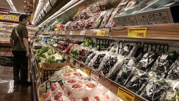 Seorang pembelanja sedang melihat produk segar di sebuah supermarket di Tokyo. (AFP via Getty Images/RICHARD A. BROOKS)