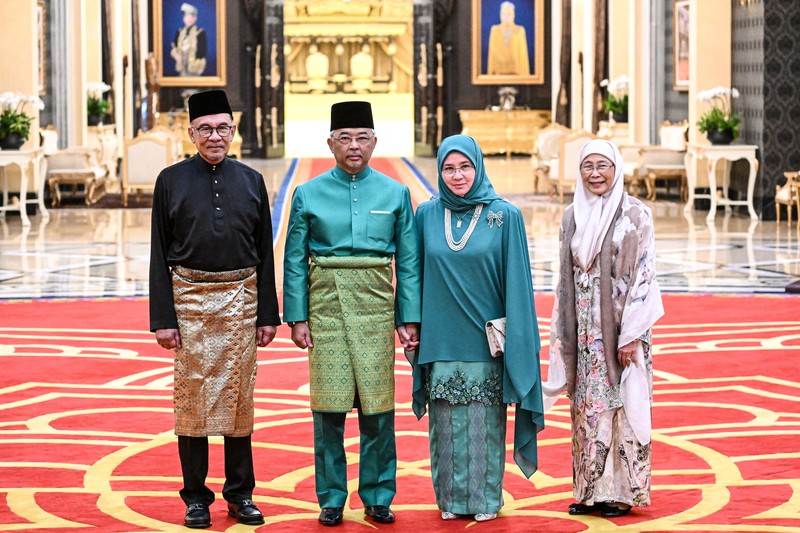 Perdana Menteri Malaysia yang baru diangkat Anwar Ibrahim (kanan) dan istrinya Wan Azizah Wan Ismail (kiri) pergi setelah upacara pengambilan sumpah di Istana Nasional di Kuala Lumpur pada 24 November 2022. (FAZRY ISMAIL/POOL/AFP via Getty Images )