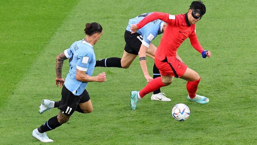 AL RAYYAN, QATAR - NOVEMBER 24:   Heung-min Son of Korea Republic battles for the ball with Martin Caceres of Uruguay during  the FIFA World Cup Qatar 2022 Group H match between Uruguay and Korea Republic at Education City Stadium on November 24, 2022 in Al Rayyan, Qatar. (Photo by Chris Brunskill/Fantasista/Getty Images)