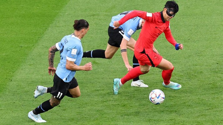 1245051548 AL RAYYAN, QATAR - NOVEMBER 24: Heung-min Son of Korea Republic battles for the ball with Martin Caceres of Uruguay during the FIFA World Cup Qatar 2022 Group H match between Uruguay and Korea Republic at Education City Stadium on November 24, 2022 in Al Rayyan, Qatar. (Photo by Chris Brunskill/Fantasista/Getty Images)