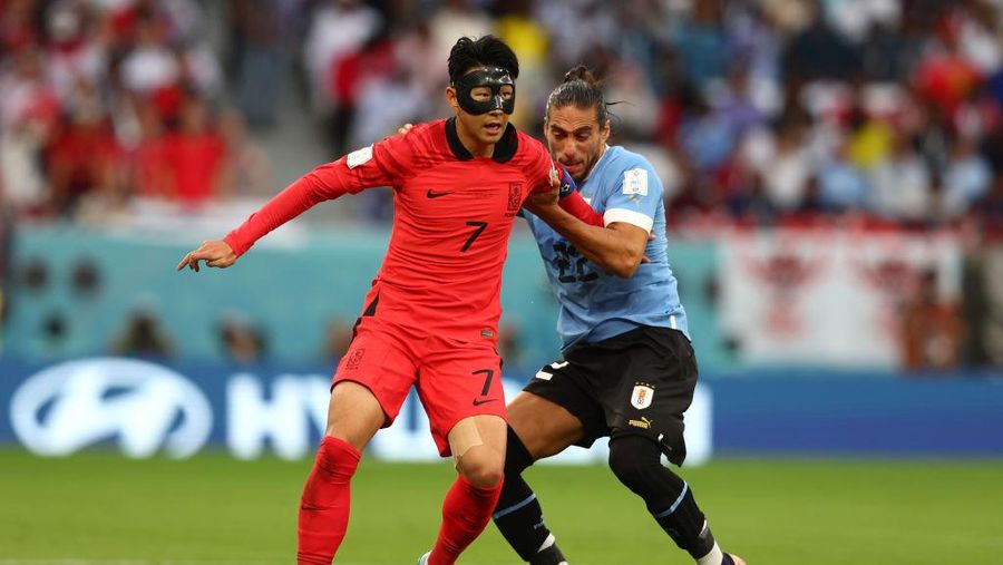 AL RAYYAN, QATAR - NOVEMBER 24:   Heung-min Son of Korea Republic battles for the ball with Martin Caceres of Uruguay during  the FIFA World Cup Qatar 2022 Group H match between Uruguay and Korea Republic at Education City Stadium on November 24, 2022 in Al Rayyan, Qatar. (Photo by Chris Brunskill/Fantasista/Getty Images)
