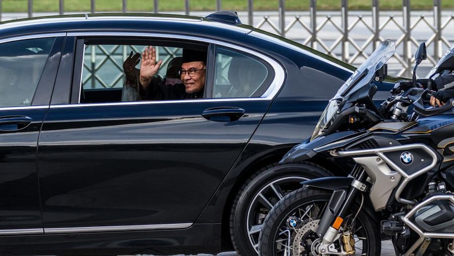 Perdana Menteri Malaysia yang baru diangkat Anwar Ibrahim (kanan) dan istrinya Wan Azizah Wan Ismail (kiri) pergi setelah upacara pengambilan sumpah di Istana Nasional di Kuala Lumpur pada 24 November 2022. (FAZRY ISMAIL/POOL/AFP via Getty Images )