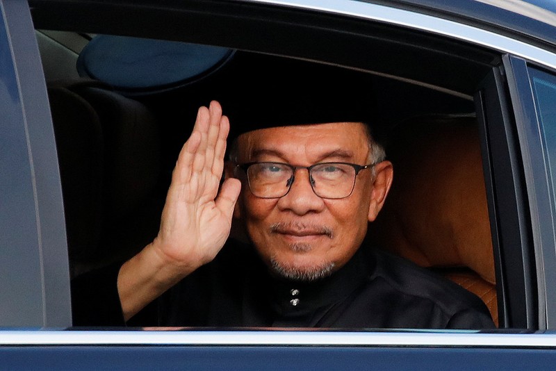 Perdana Menteri baru Malaysia Anwar Ibrahim melambai pada fotografer saat ia tiba di Istana Nasional di Kuala Lumpur, Malaysia, 24 November 2022. (Fazry Ismail/Pool via REUTERS)