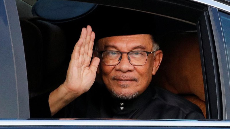 Perdana Menteri baru Malaysia Anwar Ibrahim melambai pada fotografer saat ia tiba di Istana Nasional di Kuala Lumpur, Malaysia, 24 November 2022. (Fazry Ismail/Pool via REUTERS)