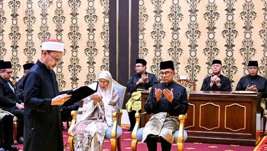 Malaysia's newly appointed Prime Minister Anwar Ibrahim (C-R) and his wife Wan Azizah Wan Ismail (C-L) take part in the swearing-in ceremony at the National Palace in Kuala Lumpur on November 24, 2022. (Photo by MOHD RASFAN / POOL / AFP)