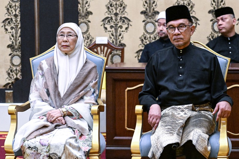 Perdana Menteri Malaysia yang baru diangkat Anwar Ibrahim (kanan) dan istrinya Wan Azizah Wan Ismail (kiri) pergi setelah upacara pengambilan sumpah di Istana Nasional di Kuala Lumpur pada 24 November 2022. Perdana Menteri Malaysia yang baru diangkat Anwar Ibrahim (kanan) dan istrinya Wan Azizah Wan Ismail (kiri) pergi setelah upacara pengambilan sumpah di Istana Nasional di Kuala Lumpur pada 24 November 2022. (FAZRY ISMAIL/POOL/AFP via Getty Images )