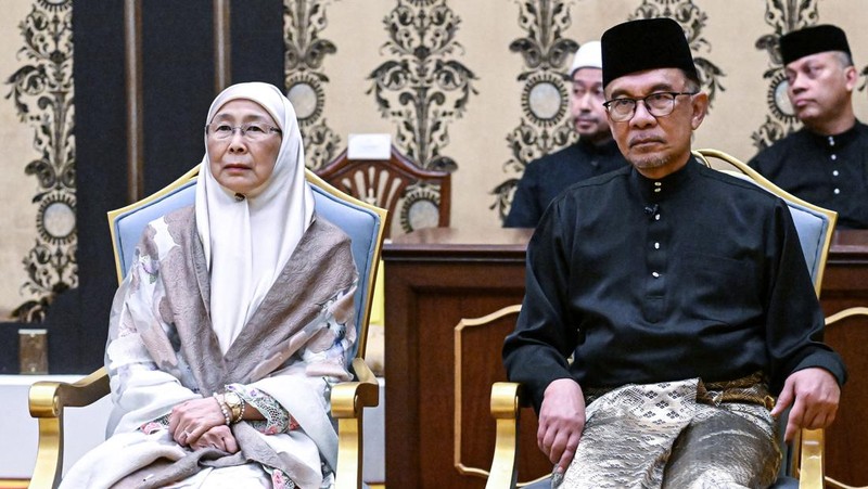 Perdana Menteri Malaysia yang baru diangkat Anwar Ibrahim (kanan) dan istrinya Wan Azizah Wan Ismail (kiri) pergi setelah upacara pengambilan sumpah di Istana Nasional di Kuala Lumpur pada 24 November 2022. (FAZRY ISMAIL/POOL/AFP via Getty Images )