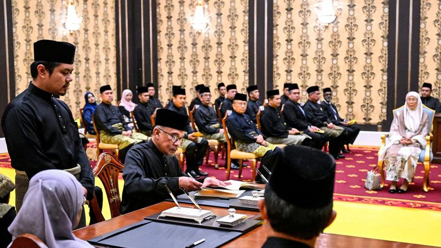 Perdana Menteri Malaysia yang baru diangkat Anwar Ibrahim (kanan) dan istrinya Wan Azizah Wan Ismail (kiri) pergi setelah upacara pengambilan sumpah di Istana Nasional di Kuala Lumpur pada 24 November 2022. (FAZRY ISMAIL/POOL/AFP via Getty Images )