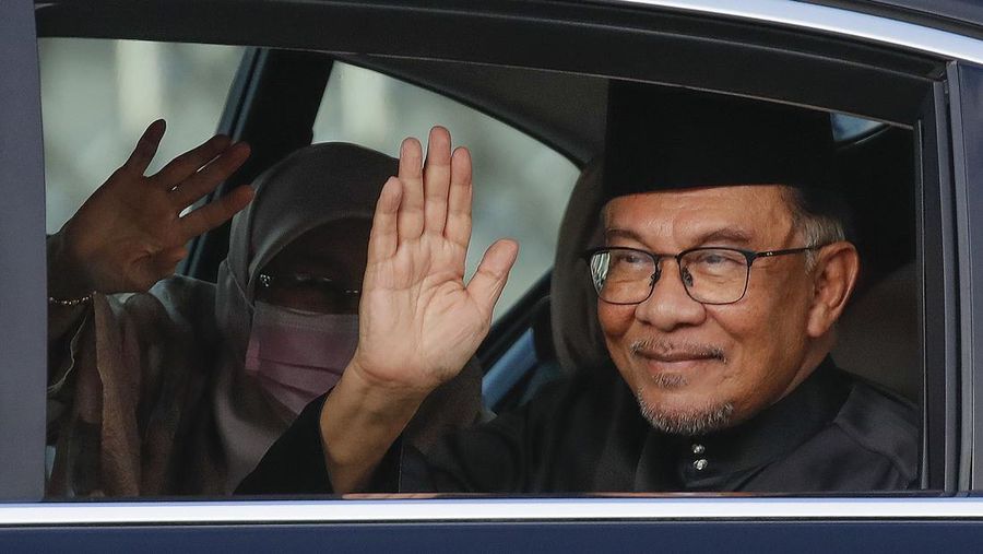 Perdana Menteri Malaysia yang baru diangkat Anwar Ibrahim dan istrinya Wan Azizah melambai kepada media ketika mereka tiba di National Place di Kuala Lumpur, Malaysia, Kamis, 24 November 2022. Raja Malaysia pada hari Kamis menunjuk Anwar sebagai perdana menteri negara itu, mengakhiri hari-hari ketidakpastian setelah pemilihan umum yang memecah belah menghasilkan Parlemen yang menggantung. (Fazry Ismail/Foto Kolam Renang via AP)
