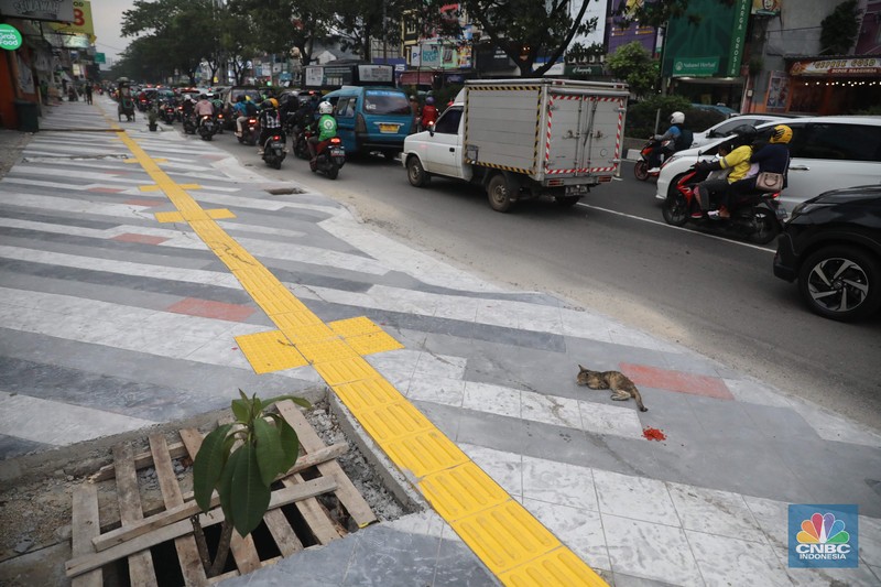 Proyek trotoar Jalan Margonda Raya baik yang ke arah Jakarta maupun sebaliknya. Secara garis besar kondisi trotoar sudah hampir tuntas tetapi lubang-lubang drainase tampak belum tertutup. (CNBC Indonesia/ Muhammad Sabki)