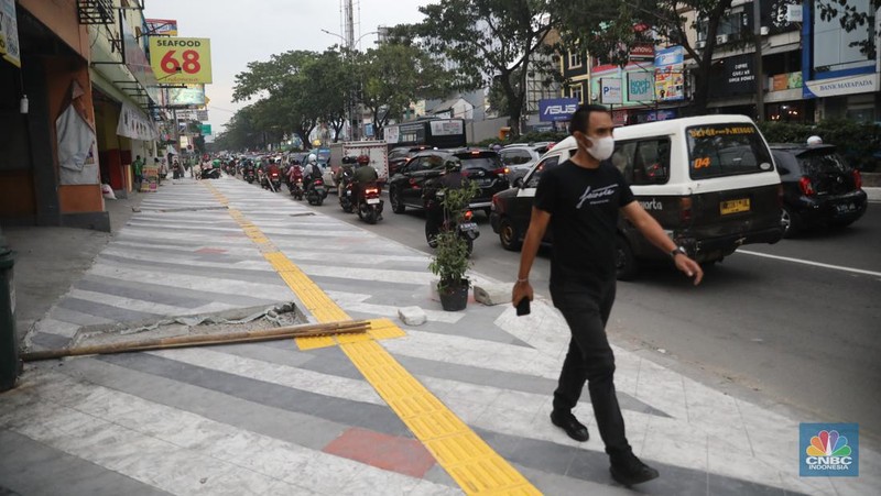 Proyek trotoar Jalan Margonda Raya baik yang ke arah Jakarta maupun sebaliknya. Secara garis besar kondisi trotoar sudah hampir tuntas tetapi lubang-lubang drainase tampak belum tertutup. (CNBC Indonesia/ Muhammad Sabki)