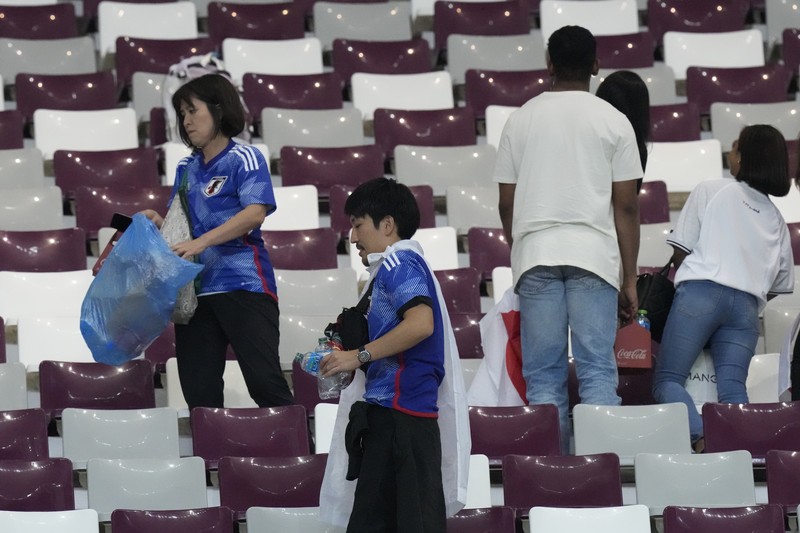 Suporter Jepang melakukan aksi bersih-bersih stadion usai kemenangan bersejarah atas Jerman di Piala Dunia 2022. (Getty Images/Alex Grimm)
