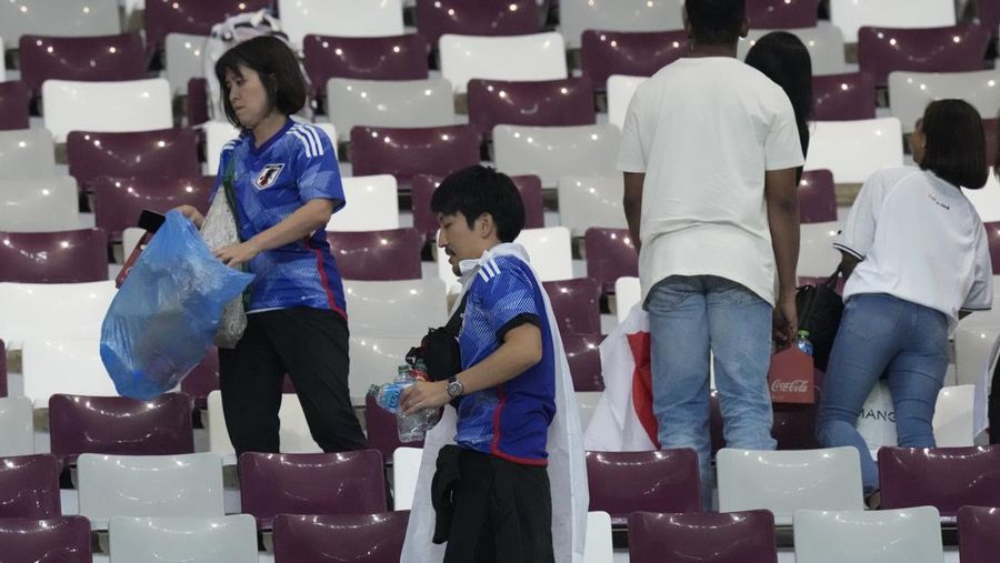 Suporter Jepang melakukan aksi bersih-bersih stadion usai kemenangan bersejarah atas Jerman di Piala Dunia 2022. (Getty Images/Alex Grimm)