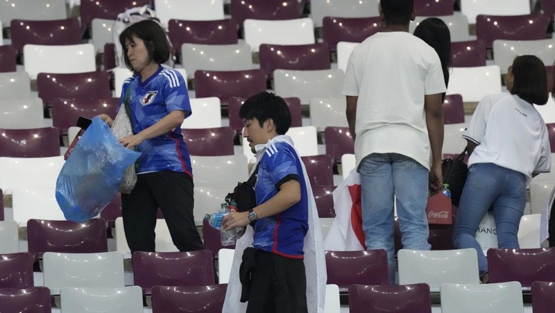 Suporter Jepang melakukan aksi bersih-bersih stadion usai kemenangan bersejarah atas Jerman di Piala Dunia 2022. (Getty Images/Alex Grimm)