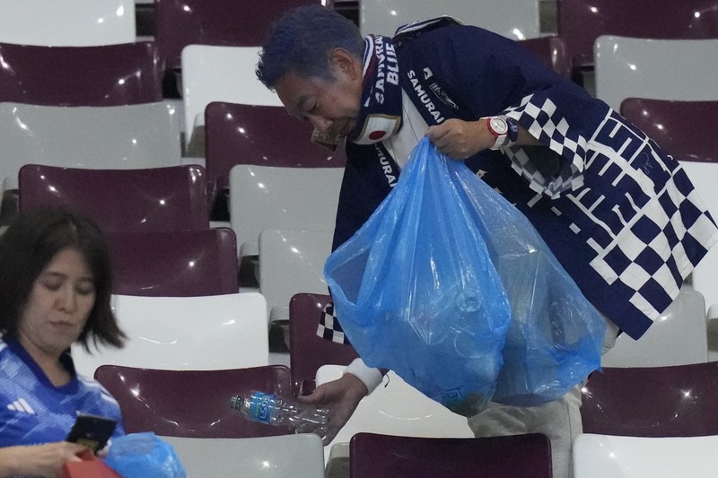 Suporter Jepang melakukan aksi bersih-bersih stadion usai kemenangan bersejarah atas Jerman di Piala Dunia 2022. (Getty Images/Alex Grimm)