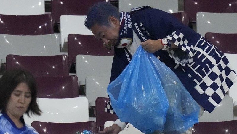 Suporter Jepang melakukan aksi bersih-bersih stadion usai kemenangan bersejarah atas Jerman di Piala Dunia 2022. (Getty Images/Alex Grimm)