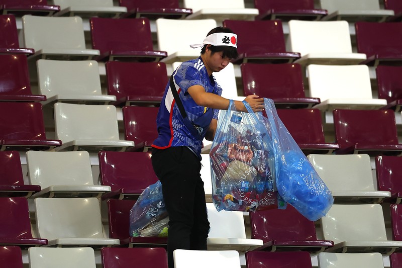 Suporter Jepang melakukan aksi bersih-bersih stadion usai kemenangan bersejarah atas Jerman di Piala Dunia 2022. (Getty Images/Alex Grimm)
