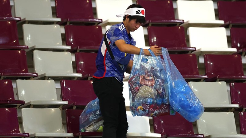 Suporter Jepang melakukan aksi bersih-bersih stadion usai kemenangan bersejarah atas Jerman di Piala Dunia 2022. (Getty Images/Alex Grimm)