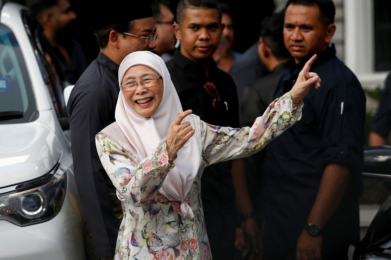 Perdana Menteri Malaysia yang baru diangkat Anwar Ibrahim (kanan) dan istrinya Wan Azizah Wan Ismail (kiri) pergi setelah upacara pengambilan sumpah di Istana Nasional di Kuala Lumpur pada 24 November 2022. (FAZRY ISMAIL/POOL/AFP via Getty Images )
