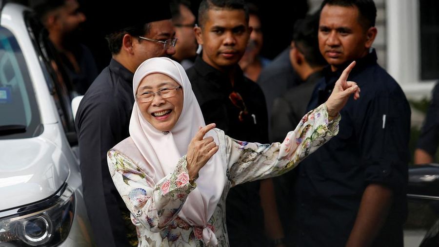 Perdana Menteri Malaysia yang baru diangkat Anwar Ibrahim (kanan) dan istrinya Wan Azizah Wan Ismail (kiri) pergi setelah upacara pengambilan sumpah di Istana Nasional di Kuala Lumpur pada 24 November 2022. (FAZRY ISMAIL/POOL/AFP via Getty Images )