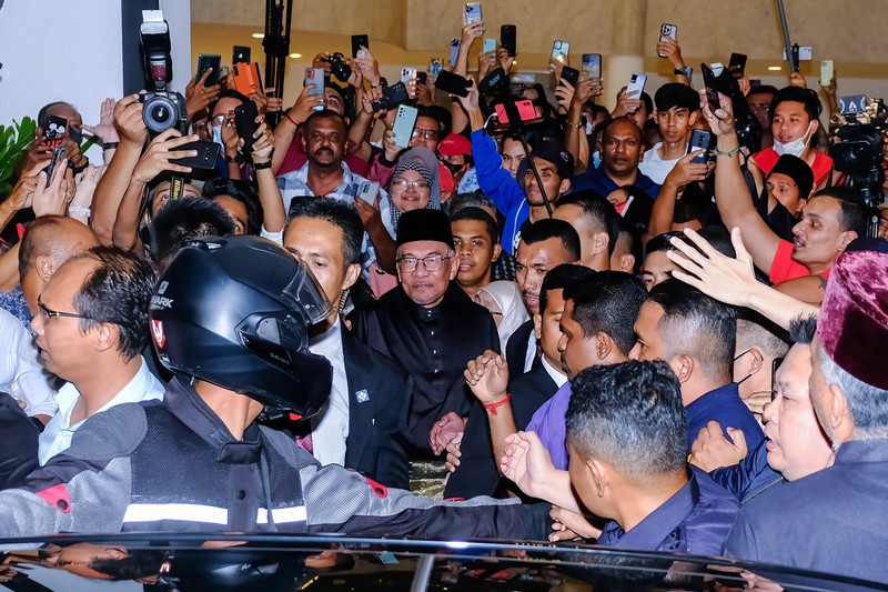 Anwar Ibrahim menyapa para pendukungnya saat meninggalkan konferensi pers. Anwar Ibrahim menyapa para pendukungnya saat meninggalkan konferensi pers. Anwar Ibrahim telah ditunjuk sebagai Perdana Menteri Malaysia ke-10 oleh Yang di-Pertuan Agong Al-Sultan Abdullah Riayatuddin Al-Mustafa Billah Shah. Anwar Ibrahim menunggu selama 24 tahun untuk menjadi Perdana Menteri. Ratusan warga Malaysia dan media berkumpul di Sungai Long Golf and Country Club untuk menyaksikan momen bersejarah tersebut. (Faris Hadziq/SOPA Images/LightRocket via Getty Images)