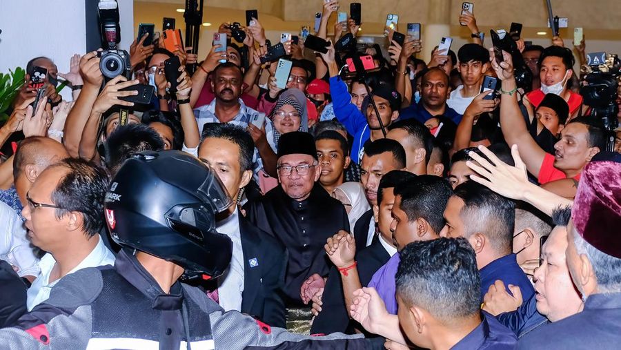 Anwar Ibrahim menyapa para pendukungnya saat meninggalkan konferensi pers. Anwar Ibrahim telah ditunjuk sebagai Perdana Menteri Malaysia ke-10 oleh Yang di-Pertuan Agong Al-Sultan Abdullah Riayatuddin Al-Mustafa Billah Shah. Anwar Ibrahim menunggu selama 24 tahun untuk menjadi Perdana Menteri. Ratusan warga Malaysia dan media berkumpul di Sungai Long Golf and Country Club untuk menyaksikan momen bersejarah tersebut. (Faris Hadziq/SOPA Images/LightRocket via Getty Images)