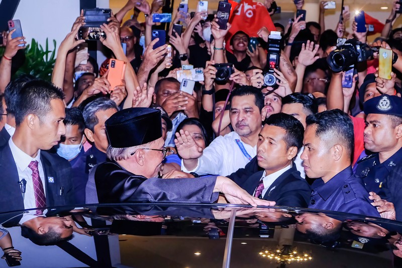 Anwar Ibrahim menyapa para pendukungnya saat meninggalkan konferensi pers. Anwar Ibrahim menyapa para pendukungnya saat meninggalkan konferensi pers. Anwar Ibrahim telah ditunjuk sebagai Perdana Menteri Malaysia ke-10 oleh Yang di-Pertuan Agong Al-Sultan Abdullah Riayatuddin Al-Mustafa Billah Shah. Anwar Ibrahim menunggu selama 24 tahun untuk menjadi Perdana Menteri. Ratusan warga Malaysia dan media berkumpul di Sungai Long Golf and Country Club untuk menyaksikan momen bersejarah tersebut. (Faris Hadziq/SOPA Images/LightRocket via Getty Images)