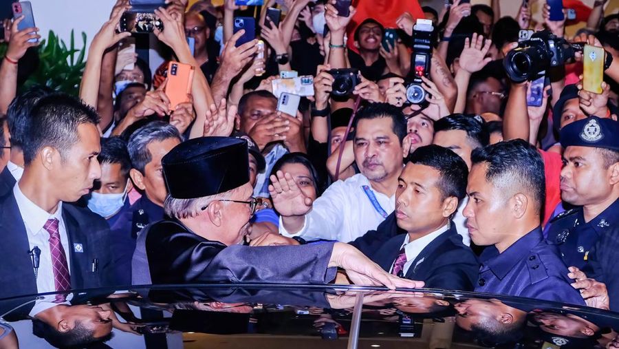 Anwar Ibrahim menyapa para pendukungnya saat meninggalkan konferensi pers. Anwar Ibrahim telah ditunjuk sebagai Perdana Menteri Malaysia ke-10 oleh Yang di-Pertuan Agong Al-Sultan Abdullah Riayatuddin Al-Mustafa Billah Shah. Anwar Ibrahim menunggu selama 24 tahun untuk menjadi Perdana Menteri. Ratusan warga Malaysia dan media berkumpul di Sungai Long Golf and Country Club untuk menyaksikan momen bersejarah tersebut. (Faris Hadziq/SOPA Images/LightRocket via Getty Images)