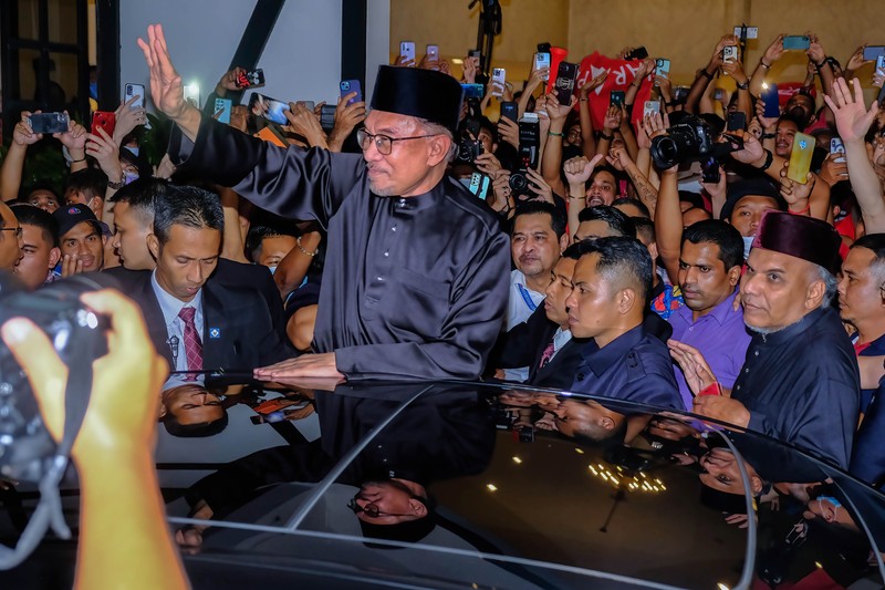 Anwar Ibrahim menyapa para pendukungnya saat meninggalkan konferensi pers. Anwar Ibrahim menyapa para pendukungnya saat meninggalkan konferensi pers. Anwar Ibrahim telah ditunjuk sebagai Perdana Menteri Malaysia ke-10 oleh Yang di-Pertuan Agong Al-Sultan Abdullah Riayatuddin Al-Mustafa Billah Shah. Anwar Ibrahim menunggu selama 24 tahun untuk menjadi Perdana Menteri. Ratusan warga Malaysia dan media berkumpul di Sungai Long Golf and Country Club untuk menyaksikan momen bersejarah tersebut. (Faris Hadziq/SOPA Images/LightRocket via Getty Images)