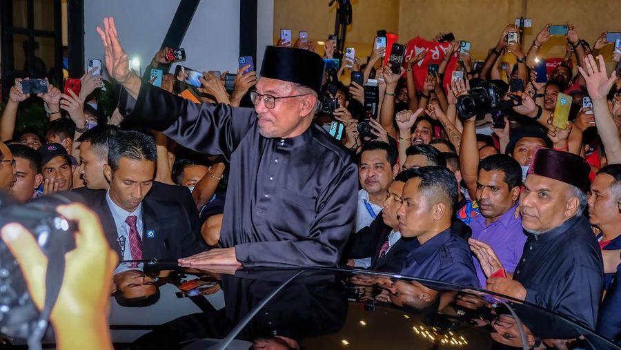 Anwar Ibrahim menyapa para pendukungnya saat meninggalkan konferensi pers. Anwar Ibrahim telah ditunjuk sebagai Perdana Menteri Malaysia ke-10 oleh Yang di-Pertuan Agong Al-Sultan Abdullah Riayatuddin Al-Mustafa Billah Shah. Anwar Ibrahim menunggu selama 24 tahun untuk menjadi Perdana Menteri. Ratusan warga Malaysia dan media berkumpul di Sungai Long Golf and Country Club untuk menyaksikan momen bersejarah tersebut. (Faris Hadziq/SOPA Images/LightRocket via Getty Images)
