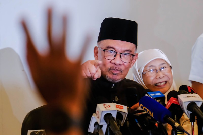 Anwar Ibrahim menyapa para pendukungnya saat meninggalkan konferensi pers. Anwar Ibrahim menyapa para pendukungnya saat meninggalkan konferensi pers. Anwar Ibrahim telah ditunjuk sebagai Perdana Menteri Malaysia ke-10 oleh Yang di-Pertuan Agong Al-Sultan Abdullah Riayatuddin Al-Mustafa Billah Shah. Anwar Ibrahim menunggu selama 24 tahun untuk menjadi Perdana Menteri. Ratusan warga Malaysia dan media berkumpul di Sungai Long Golf and Country Club untuk menyaksikan momen bersejarah tersebut. (Faris Hadziq/SOPA Images/LightRocket via Getty Images)