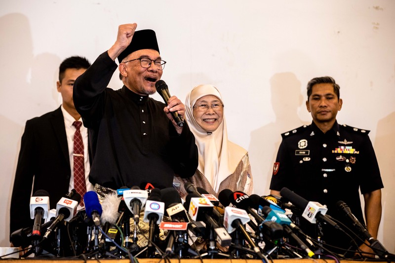 Anwar Ibrahim menyapa para pendukungnya saat meninggalkan konferensi pers. Anwar Ibrahim menyapa para pendukungnya saat meninggalkan konferensi pers. Anwar Ibrahim telah ditunjuk sebagai Perdana Menteri Malaysia ke-10 oleh Yang di-Pertuan Agong Al-Sultan Abdullah Riayatuddin Al-Mustafa Billah Shah. Anwar Ibrahim menunggu selama 24 tahun untuk menjadi Perdana Menteri. Ratusan warga Malaysia dan media berkumpul di Sungai Long Golf and Country Club untuk menyaksikan momen bersejarah tersebut. (Faris Hadziq/SOPA Images/LightRocket via Getty Images)