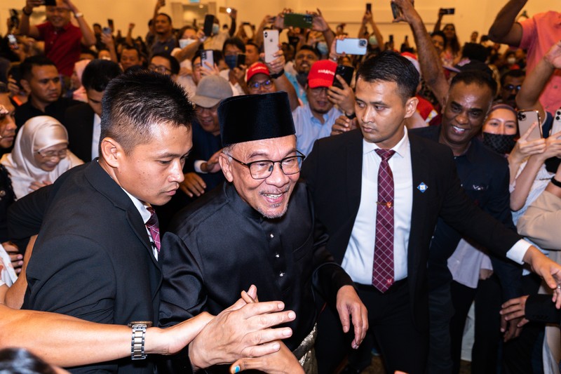 Anwar Ibrahim menyapa para pendukungnya saat meninggalkan konferensi pers. Anwar Ibrahim telah ditunjuk sebagai Perdana Menteri Malaysia ke-10 oleh Yang di-Pertuan Agong Al-Sultan Abdullah Riayatuddin Al-Mustafa Billah Shah. Anwar Ibrahim menunggu selama 24 tahun untuk menjadi Perdana Menteri. Ratusan warga Malaysia dan media berkumpul di Sungai Long Golf and Country Club untuk menyaksikan momen bersejarah tersebut. (Faris Hadziq/SOPA Images/LightRocket via Getty Images)