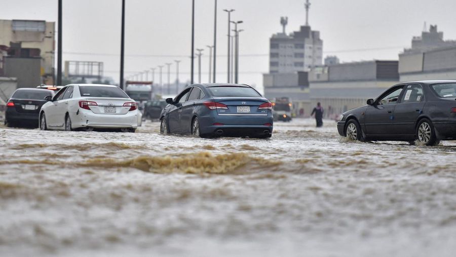Mobil melewati jalan yang banjir setelah hujan lebat di kota pesisir Saudi Jeddah pada 24 November 2022, yang menunda penerbangan, memaksa penangguhan sekolah dan menutup jalan ke Mekah, kota paling suci bagi umat Islam. - Jeddah, kota berpenduduk sekitar empat juta orang yang terletak di Laut Merah, sering disebut sebagai 