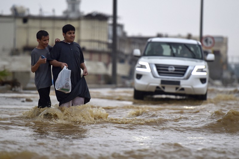 Sebuah kendaraan melewati jalan yang banjir setelah hujan lebat, di Jeddah, Arab Saudi, 24 November 2022. Mobil melewati jalan yang banjir setelah hujan lebat di kota pesisir Saudi Jeddah pada 24 November 2022, yang menunda penerbangan, memaksa penangguhan sekolah dan menutup jalan ke Mekah, kota paling suci bagi umat Islam. - Jeddah, kota berpenduduk sekitar empat juta orang yang terletak di Laut Merah, sering disebut sebagai
