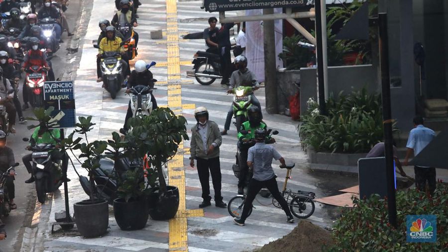 Sejumlah kendara bermotor melintas di trotoar di Kawasan Margonda Depok, Jawa Barat, Jumat, 25/11. Pelebaran trotoar di Jalan Margonda Raya, Depok, Jawa Barat (Jabar) ditargetkan rampung pada akhir tahun 2022. (CNBC Indonesia/Muhammad Sabki)