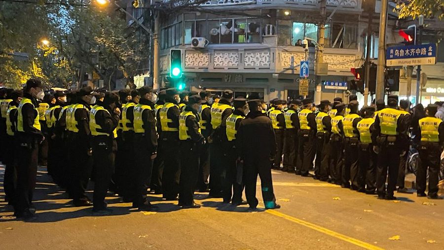 Police officers gather at the site where a protest against COVID-19 curbs took place the night before, following the deadly Urumqi fire, in Shanghai, China November 27, 2022. (REUTERS/Josh Horwitz)