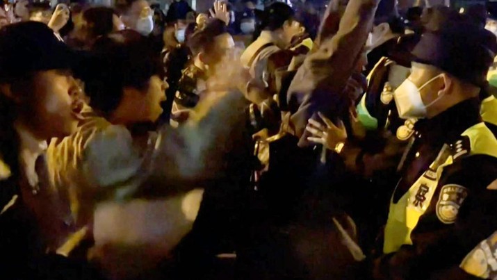 This frame grab from eyewitness video footage made available via AFPTV on November 27, 2022 shows demonstrators shouting slogans as police hold their positions, in Shanghai. - Angry crowds took to the streets in Shanghai in the early hours of November 27 and videos on social media showed protests in other cities across China, as public opposition to the government's hardline zero-Covid policy mounts. (-/AFPTV/AFP via Getty Images)